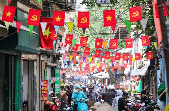 Rực rỡ cờ đỏ sao vàng, cờ Đảng trong ngõ trên phố 8/3, quận Hai Bà Trưng. Ảnh: Khánh Hoà - TTXVN