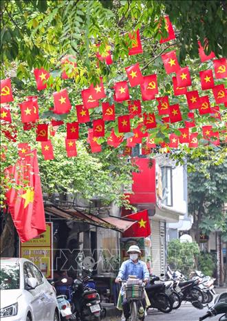 Rực rỡ cờ đỏ sao vàng, cờ Đảng trên phố Hồng Mai, quận Hai Bà Trưng. Ảnh: Khánh Hoà - TTXVN