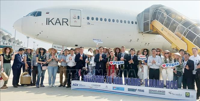 Russian visitors pose for a group photo after landing at Cam Ranh International Airport. VNA Photo: Tiên Minh