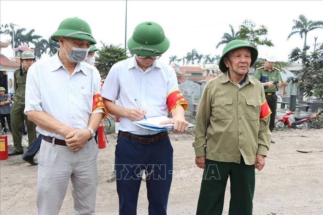 Lực lượng chức năng và chính quyền địa phương tiến hành lập biên bản về việc đình ông Đặng Đức Chúc không chấp hành việc giải tỏa vi phạm. Ảnh: Mạnh Minh – TTXVN