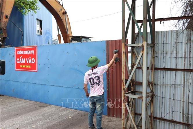 Lực lượng chức năng đã phải sử dụng các biện pháp cưỡng chế để vào khu vực thửa đất trên để đo đạc, xác định mốc giới, giải tỏa vi phạm. Ảnh: Mạnh Minh - TTXVN
