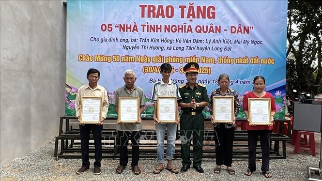 Đại tá Nguyễn Hoàng Tấn, Phó Chính ủy Bộ Chỉ huy Quân sự tỉnh Bà Rịa-Vũng Tàu với đại diện các gia đình nhận nhà ngày 18/4. Ảnh: TTXVN phát 