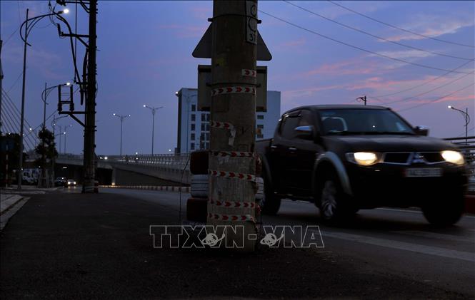 Cột điện “mọc” ở giữa đường Nguyễn Tất Thành, thành phố Vĩnh Yên có thể khiến các phương tiện tham gia lưu thông xảy ra va chạm nguy hiểm, nhất là vào buổi tối tầm nhìn bị hạn chế. Ảnh: Hoàng Hùng-TTXVN