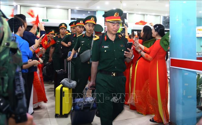 Sau chuyến hành quân dài, các chiến sĩ vừa di chuyển ra khu vực tập kết, vừa gọi điện thoại thông báo cho người dân đã tới nơi an toàn. Ảnh: Lê Xuân-TTXVN