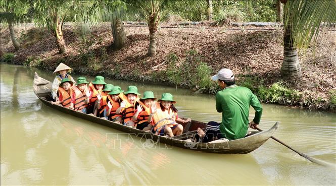 Các du khách “nhí” trải nghiệm chèo xuồng ba lá, hoạt động được yêu thích tại điểm du lịch OCOP 3 sao Nông trại Phan Nam. Ảnh: Thanh Sang- TTXVN