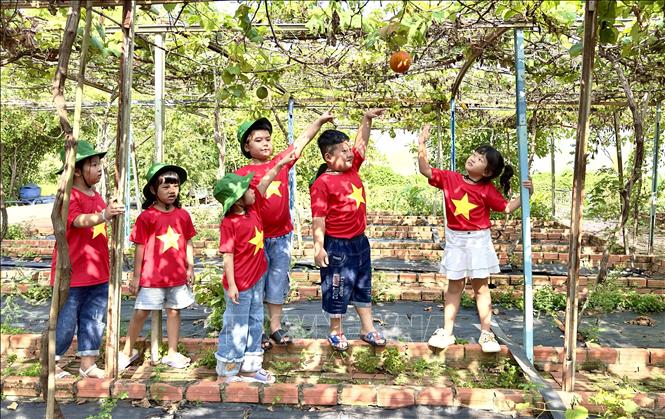 Các học sinh thích thú tham quan khu trồng gấc tại điểm du lịch OCOP 3 sao Nông trại Phan Nam. Ảnh: Thanh Sang- TTXVN