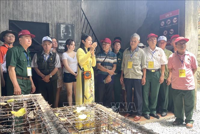 Các cựu chiến binh tỉnh Cao Bằng và Bắc Kạn nghe thuyết minh về mô hình chuồng cọp phục dựng. Ảnh: Hương Giang - TTXVN