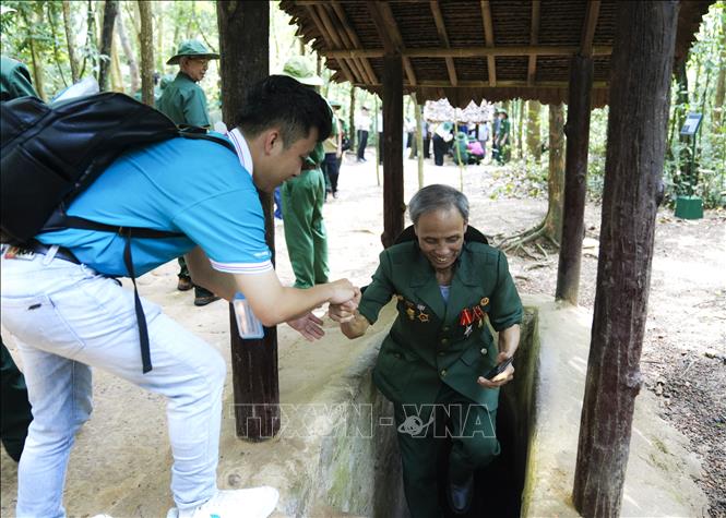 Các cựu chiến binh trải nghiệm địa đạo trong lòng đất, tại Khu di tích lịch sử Địa đạo Củ Chi.  Ảnh: Hương Giang - TTXVN
