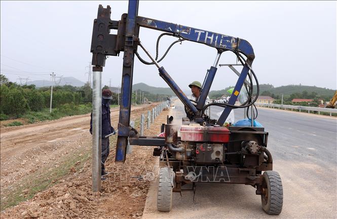 Lắp đặt cột hàng rào, hộ lan hai bên đường, đoạn qua tỉnh Quảng Bình. Ảnh: Quốc Khánh - TTXVN