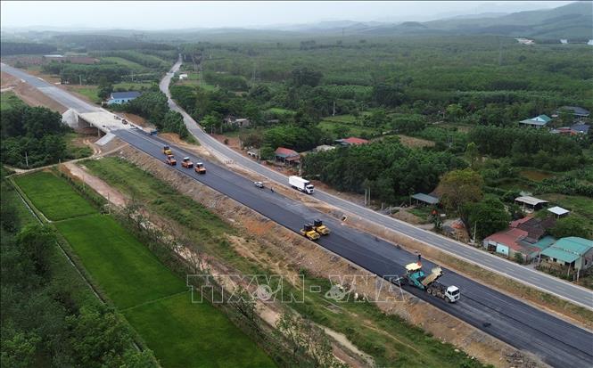 Nhà thầu đang khẩn trương tập trung thảm nhựa đoạn đường chạy song hành với đường Hồ Chí Minh trên địa bàn tỉnh Quảng Bình. Ảnh: Quốc Khánh - TTXVN