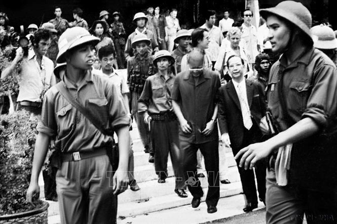 Đại úy Phạm Xuân Thệ (bên phải), Trung đoàn phó Trung đoàn 66, Sư đoàn 304 (Quân đoàn 2) cùng các chiến sĩ Quân giải phóng dẫn giải Tổng thống Dương Văn Minh và Thủ tướng Vũ Văn Mẫu của Ngụy quyền Sài Gòn tới Đài Phát thanh để đọc lời tuyên bố đầu hàng vô điều kiện. Ảnh: TTXVN