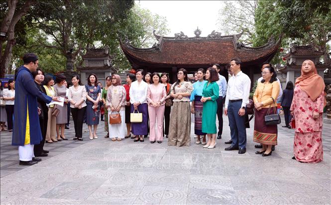 Bà Lê Thị Bích Trân, Phu nhân Thủ tướng Chính phủ Phạm Minh Chính và Nhóm Phụ nữ cộng đồng ASEAN tại Hà Nội nghe giới thiệu về lịch sử Đền Đô. Ảnh: Phạm Kiên - TTXVN