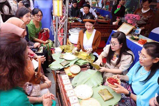 Bà Lê Thị Bích Trân, Phu nhân Thủ tướng Chính phủ Phạm Minh Chính và nhóm Phụ nữ cộng đồng ASEAN tại Hà Nội trải nghiệm làm bánh phu thê. Ảnh: Phạm Kiên - TTXVN