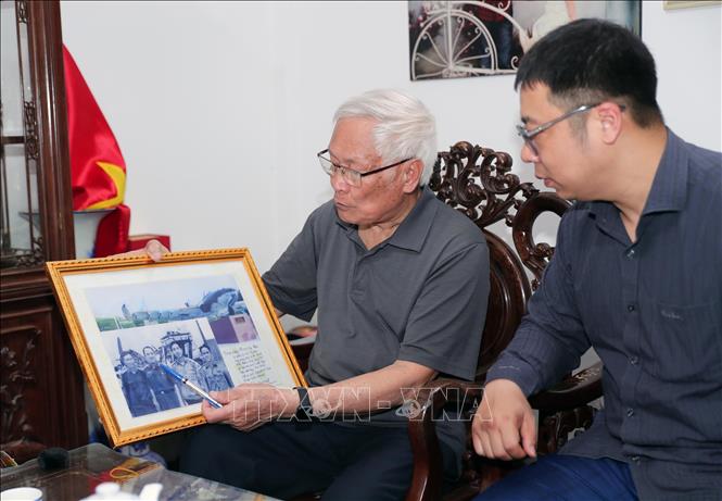 Thượng tá Phạm Chu Hải (trái) giới thiệu những hình ảnh và kỷ vật của mình thời chiến đấu.  Ảnh: Trọng Đức - TTXVN