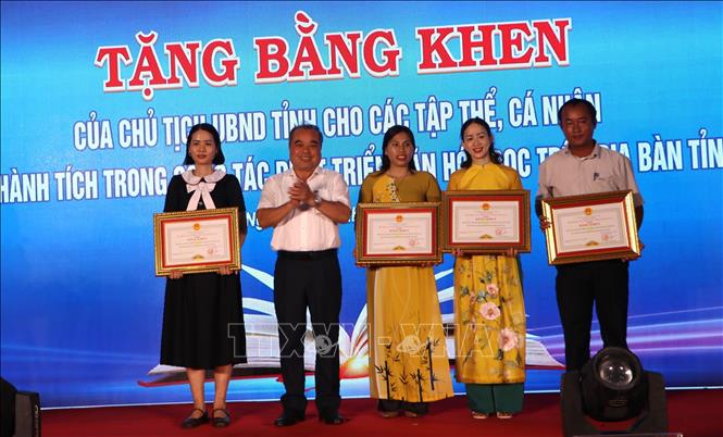 Phó Chủ tịch thường trực UBND tỉnh Quảng Ngãi Trần Hoàng Tuấn trao Bằng khen của Chủ tịch UBND tỉnh cho các tập thể có nhiều đóng góp tích cực trong việc phát triển văn hoá đọc. Ảnh: Đinh Hương - TTXVN
