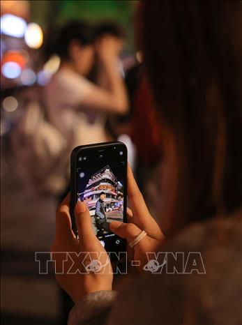 Người dân đến trước toà nhà “Hàm cá mập” để lưu lại những khoảnh khắc cuối cùng trước khi tòa nhà này bị phá dỡ. Ảnh: Hoàng Hiếu - TTXVN