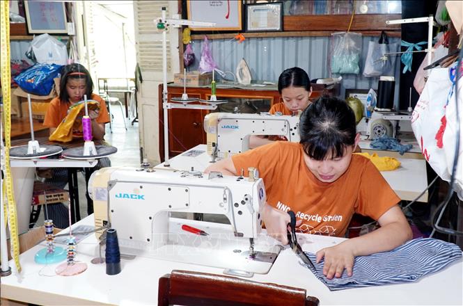 Các thành viên “Vườn tái chế - NNC” tạo ra các sản phẩm có ích, đa năng, hữu dụng từ rác thải (vỏ lon nhôm, chai nhựa, bì carton, vải vụn...). Ảnh: Lê Phước Ngọc - TTXVN

