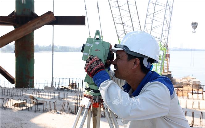 Cán bộ kỹ thuật nhà thầu Khang Nguyên đo đạc để lắp đặt hệ thống vòm thép cho cầu Nhật Lệ 3. Ảnh: Quốc Khánh - TTXVN