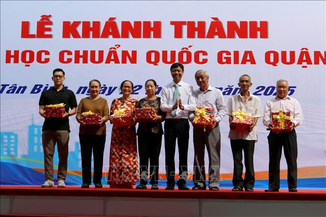 Lãnh đạo quận Tân Bình, Thành phố Hồ Chí Minh tặng quà cho các hộ dân có đất trong khu vực sớm đồng thuận giải tỏa, thực hiện chủ trương xây dựng trường. Ảnh: Thanh Vũ-TTXVN 