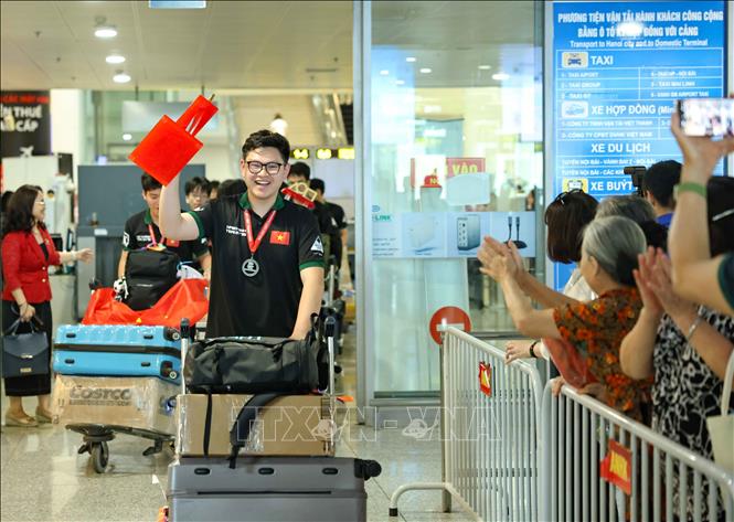 Các thành viên đội tuyển mang vinh quang, chiến thắng trở về. Ảnh: Thanh Tùng - TTXVN