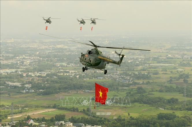 Biên đội máy bay trực thăng mang theo cờ Tổ quốc, cờ Đảng bay trên bầu trời TP Hồ Chí Minh. Ảnh: Mạnh Linh-TTXVN
