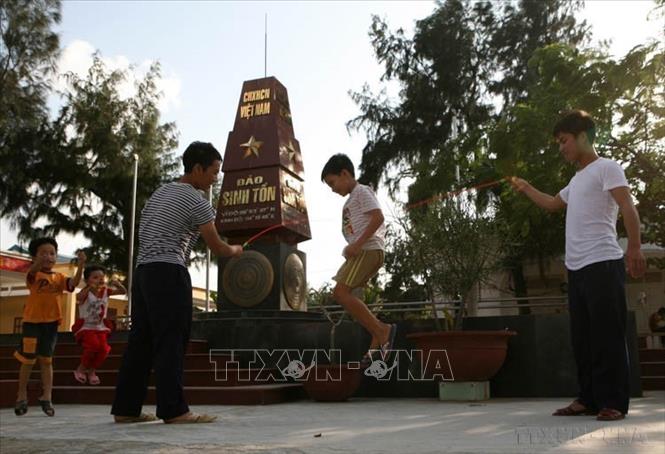 Thiếu nhi trên xã đảo Sinh Tồn vui chơi cùng những người lính đảo (2010). Ảnh: Xuân Trường - TTXVN
