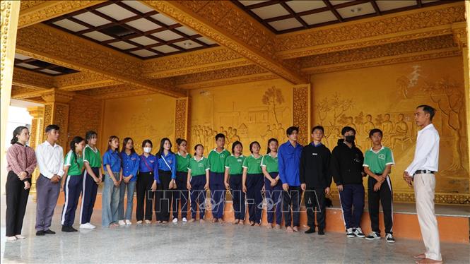 Đoàn viên thanh niên huyện Châu Thành nghe thuyết minh về Tháp 4 sư liệt sĩ (tỉnh Kiên Giang). Ảnh: Văn Sĩ - TTXVN                              