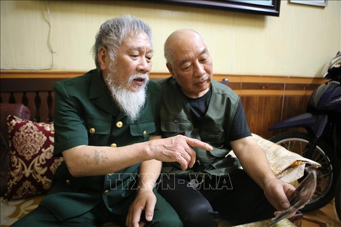 Ông Nguyễn Thế Tám và cựu chiến binh trong tổ dân phố ôn lại kỷ niệm thời gian trong quân ngũ. Ảnh: Công Luật - TTXVN