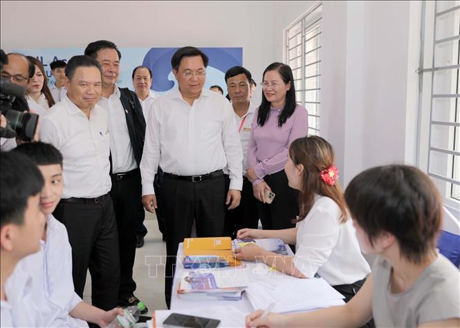 Chủ tịch UBND tỉnh Vĩnh Phúc (đeo kính, áo trắng) thăm quan một gian hàng tại hội chợ. Ảnh: Hoàng Hùng - TTXVN