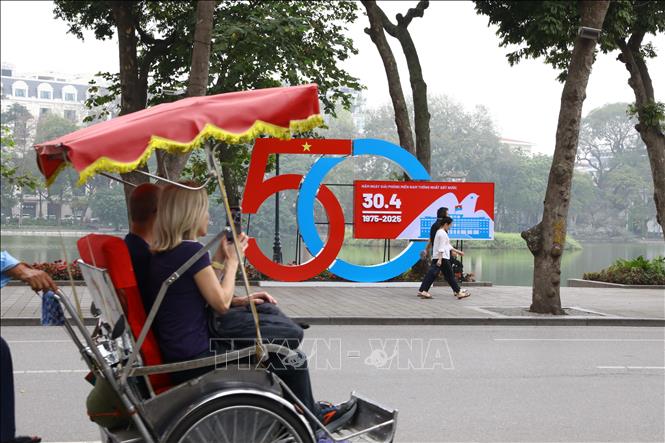 Khẩu hiệu chào mừng 50 năm thống nhất đất nước trên đường phố Hà Nội. Ảnh: Quốc Lũy-TTXVN