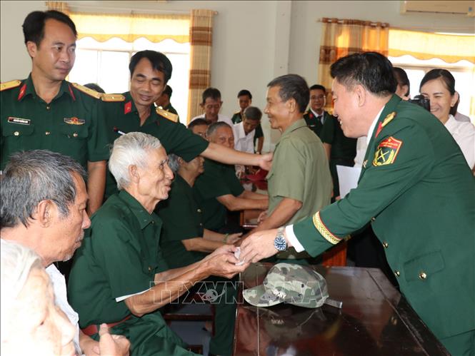 Đại tá Thái Thành Đức, Phó Chủ nhiệm Chính trị Quân khu 7 tặng quà các gia đình chính sách, người có công với cách mạng. Ảnh: K GỬIH -TTXVN
