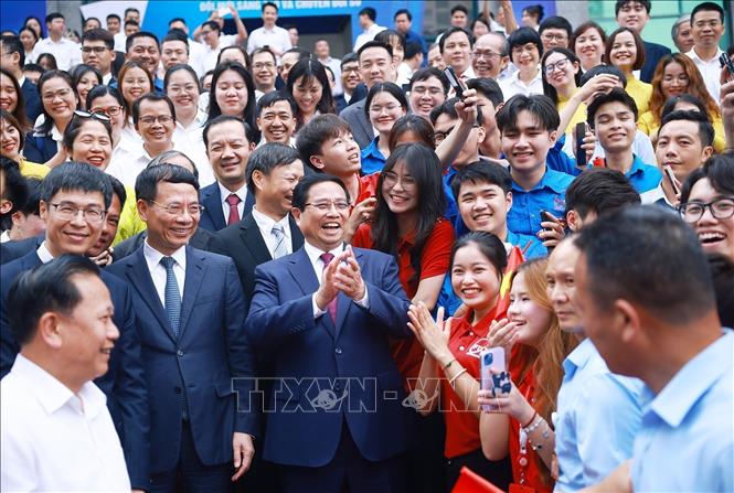 Prime Minister Pham Minh Chinh with the leadership and students of the Posts and Telecommunications Institute of Technology (PTIT). VNA Photo: Dương Giang