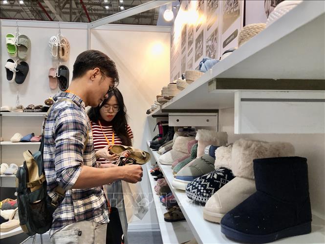 Visitors pick out footwear at the fair. VNA Photo: Mỹ Phương