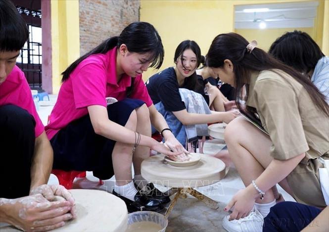 Học sinh tỉnh Fukuoka (Nhật Bản) trải nghiệm làm gốm khi tham quan làng nghề Bát Tràng (Hà Nội, 10/08/2023). Ảnh: TTXVN phát