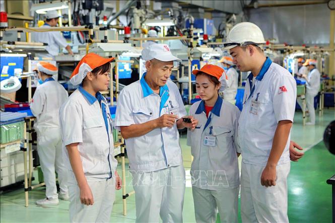Chuyên gia Nhật Bản trao đổi công việc với công nhân Việt Nam tại Công ty TNHH Yokoi Muold Việt Nam (vốn đầu tư của Nhật Bản) trong khu công nghiệp Đình Trám (Bắc Giang). Ảnh: Thành Đạt – TTXVN