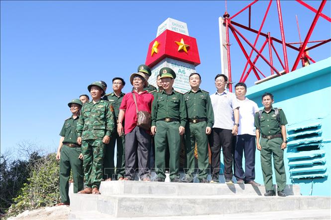 Đoàn công tác chụp ảnh lưu niệm tại cột mốc chủ quyền trên đảo Hòn Hải. Ảnh: Nguyễn Thanh - TTXVN