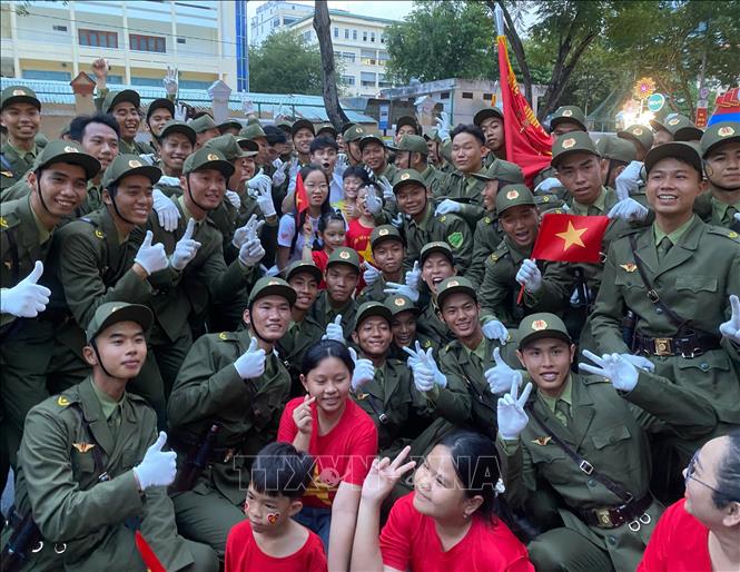 Các học viên khối nam lực lượng tham gia bảo vệ an ninh trật tự cơ sở chụp ảnh cùng người dân. Ảnh: Hồng Giang - TTXVN