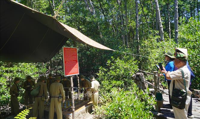 Du khách tìm hiểu về khu trưng bày mô phỏng về trận đánh kho xăng Nhà Bè của các chiến sĩ Đặc công Rừng Sác. Ảnh: Hữu Duyên - TTXVN