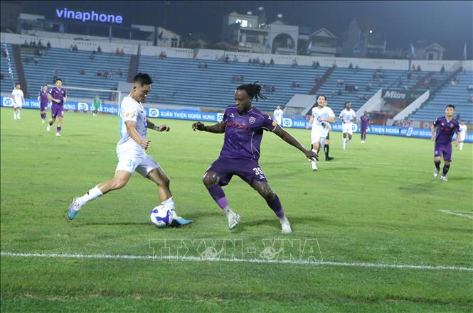 Tình huống tranh chấp bóng giữa các cầu thủ Thép Xanh Nam Định (áo trắng) và các cầu thủ Bình Dương. Ảnh: Công Luật - TTXVN