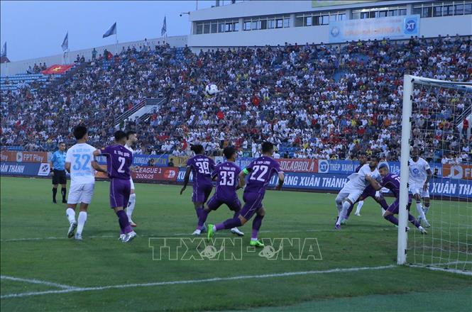 Tình huống tranh chấp bóng giữa các cầu thủ Thép Xanh Nam Định (áo trắng) và các cầu thủ Bình Dương. Ảnh: Công Luật - TTXVN