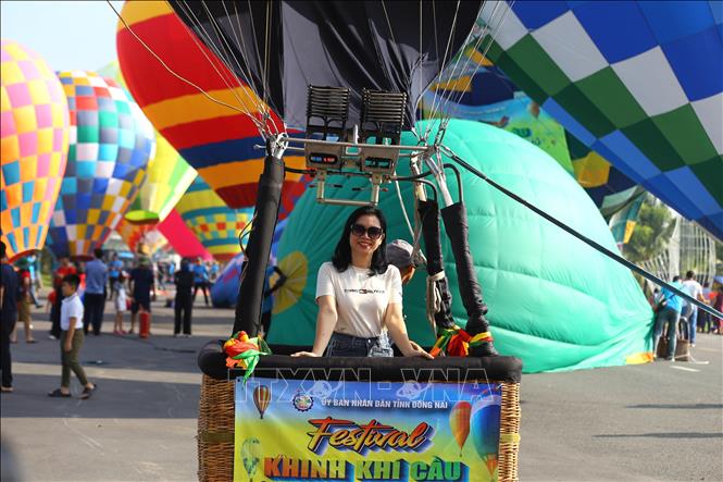 A visitor poses for a photo with a hot air balloon. VNA Photo: Lê Xuân
