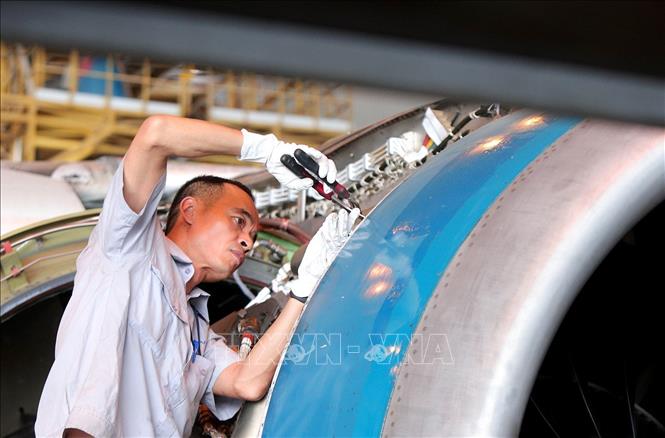 Kỹ thuật viên kiểm tra hệ thống phản lực trên máy bay. Ảnh: Tuấn Anh - TTXVN