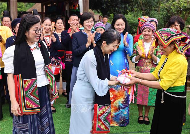 Nghệ nhân Lò Thị Tóm đại diện nhóm đồng bào Thái tặng bà Lê Thị Bích Trân, Phu nhân Thủ tướng Phạm Minh Chính và bà Ishiba Yoshiko, Phu nhân Thủ tướng Nhật Bản khăn Piêu và quả còn. Ảnh: Minh Đức – TTXVN