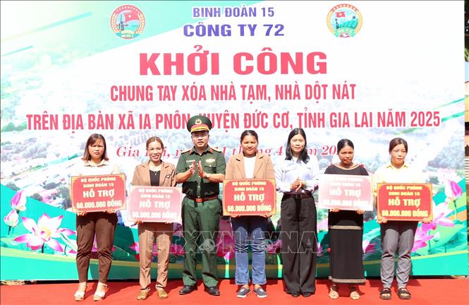 Binh đoàn 15 trao tặng tiền hỗ trợ thực hiện chương trình xoá nhà tạm, dột nát cho các gia đình được thụ hưởng. Ảnh: Quang Thái - TTXVN