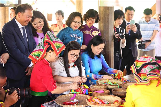The two ladies experience in making crafts of Thai ethnic group. VNA Photo: Minh Đức 
