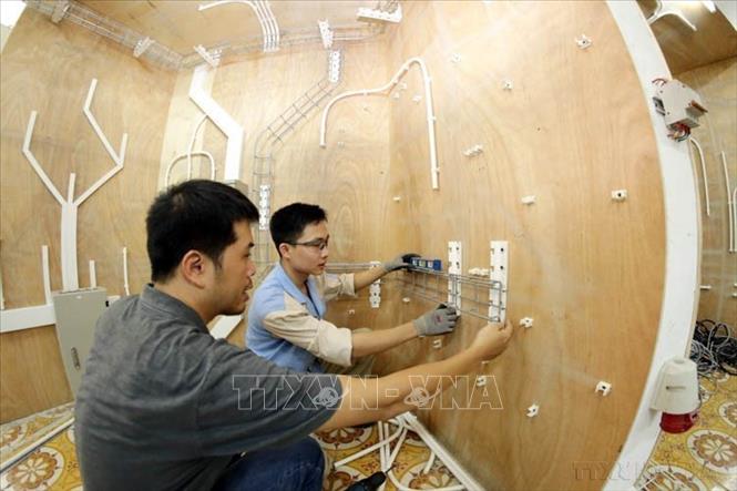 Chuyên gia Nguyễn Quang Huy đang huấn luyện cho thí sinh Nguyễn Văn Minh nghề Lắp đặt điện tại Trường CĐ Cơ điện Hà Nội để chuẩn bị cho Kỳ thi tay nghề thế giới lần thứ 45. Ảnh: Anh Tuấn – TTXVN