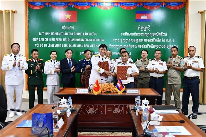 Thượng tá Mai Đăng Danh, Phó Tư lệnh, Tham mưu trưởng Bộ Tư lệnh Vùng 5 Hải quân và Phó Đô đốc May Dina Chỉ huy trưởng Căn cứ biển Ream trao biên bản ghi nhớ công tác phối hợp trong thời gian tới. Ảnh: TTXVN phát