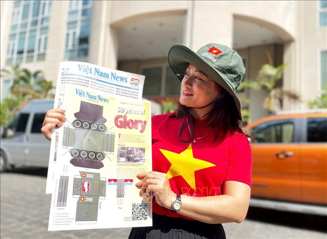 Chị Hoàng Phương (quận 2, Thành phố Hồ Chí Minh) mua được ấn phẩm Mô hình cắt dán xe tăng 390. Ảnh: Hồng Đạt - TTXVN
