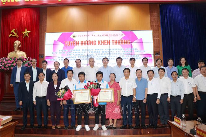 Hai anh em song sinh Nguyễn Trí Hiền và Nguyễn Trí Hậu được lãnh đạo tỉnh Quảng Nam biểu dương, khen thưởng. Ảnh: Đoàn Hữu Trung - TTXVN