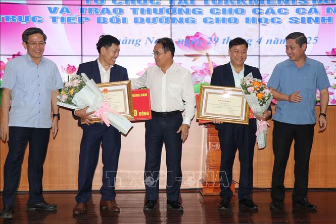 Lãnh đạo tỉnh Quảng Nam tặng quà cho các thầy giáo trực tiếp bồi dưỡng cho hai học sinh đạt Huy chương Vàng. Ảnh: Đoàn Hữu Trung -TTXVN
